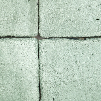 Cuatro Azulejos cuadradas de terracota texturizadas en verde suave, dispuestas estrechamente con espacios visibles, forman un pa