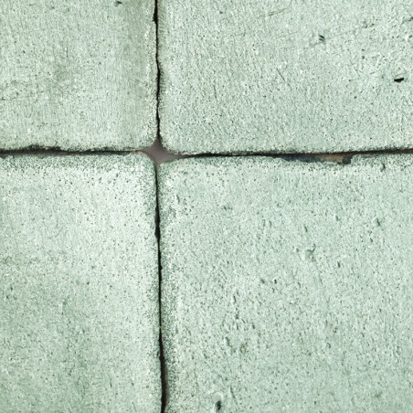 Cuatro Azulejos cuadradas de terracota texturizadas en verde suave, dispuestas estrechamente con espacios visibles, forman un pa