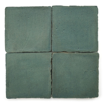 Cuatro Azulejos cuadradas de terracota de color azul verdoso están dispuestas en una cuadrícula de dos por dos, mostrando una su