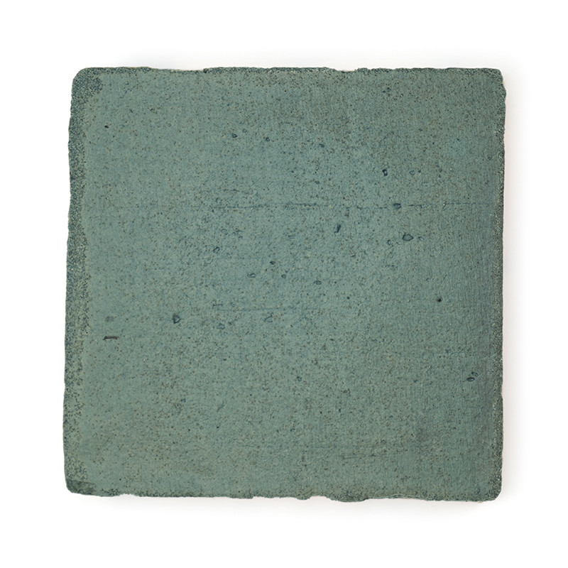 Baldosa cuadrada de terracota, plana, con un acabado verde apagado y una superficie texturizada ligeramente rugosa sobre un fond