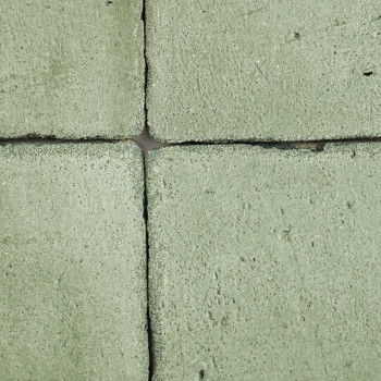 Vier grüne Terrakottafliesen bilden ein Quadrat, das an den Rändern eng aneinandergereiht ist und eine raue Textur aufweist.