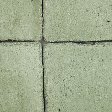 Vier grüne Terrakottafliesen bilden ein Quadrat, das an den Rändern eng aneinandergereiht ist und eine raue Textur aufweist.