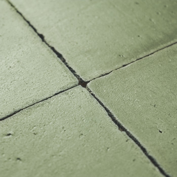 Los azulejos de terracota verde forman un patrón cuadrado con líneas de lechada visibles, creando una superficie rústica y textu