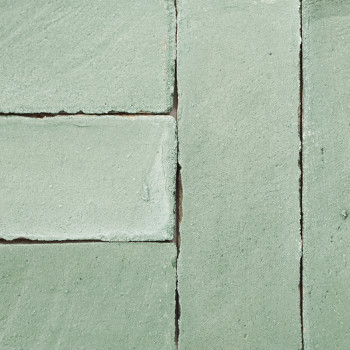 Groene terracottategels zijn netjes uitgelijnd en vormen een rechthoekig patroon tegen een vlak, uniform oppervlak.