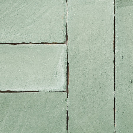 Groene terracottategels zijn netjes uitgelijnd en vormen een rechthoekig patroon tegen een vlak, uniform oppervlak.