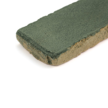 Baldosa rectangular de terracota con una superficie vidriada de color verde, apoyada sobre un fondo blanco.