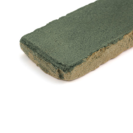 Baldosa rectangular de terracota con una superficie vidriada de color verde, apoyada sobre un fondo blanco.