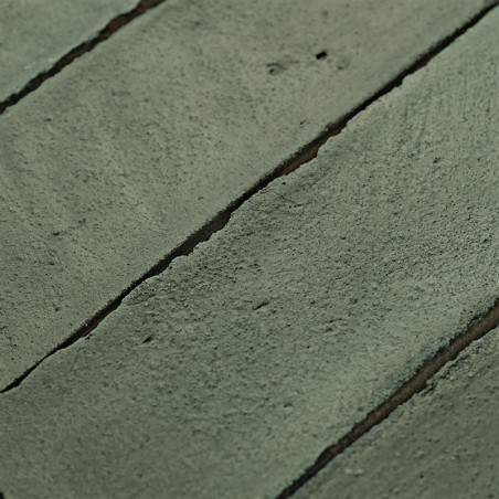 Los azulejos de terracota verde están alineadas con líneas de lechada visibles, creando una textura rústica en la superficie de 