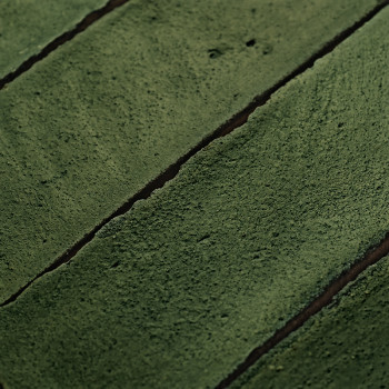 Les carreaux de terre cuite à la texture verte rugueuse sont étroitement serrés les uns contre les autres, formant une surface c