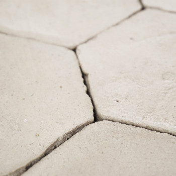 Los azulejos hexagonales de terracota se entrelazan perfectamente, formando una superficie texturizada, colocadas muy juntas en 