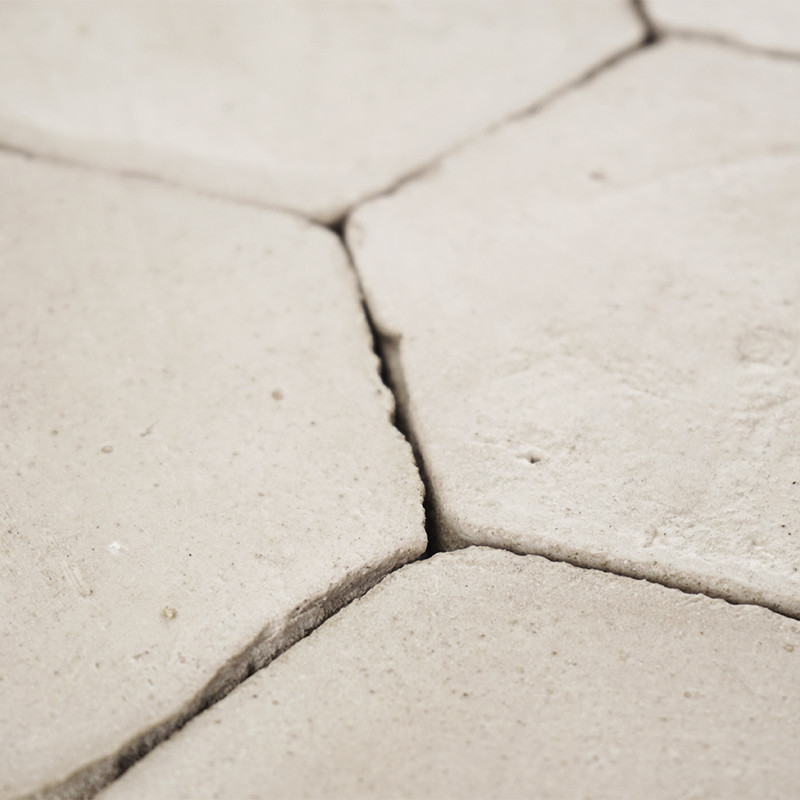 Sechseckige Terrakottafliesen greifen nahtlos ineinander und bilden eine strukturierte Oberfläche, die in einer minimalistischen