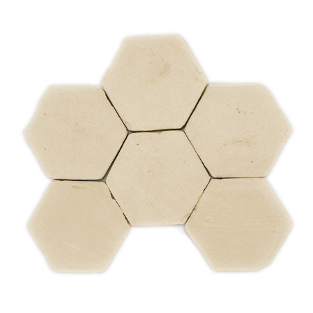 Zes beige zeshoekige terracottategels samengevoegd tot een honingraatpatroon op een effen witte achtergrond.