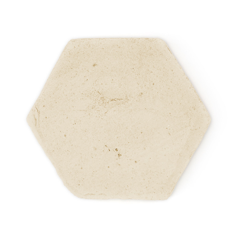 Zeshoekige terracotta tegel rustend op een effen witte achtergrond, met een glad, lichtbeige oppervlak met subtiele textuur.