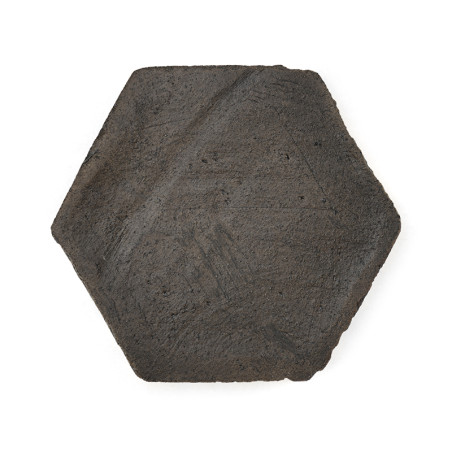Azulejos de terracota hexagonales con textura rugosa, colocadas sobre un fondo blanco liso.