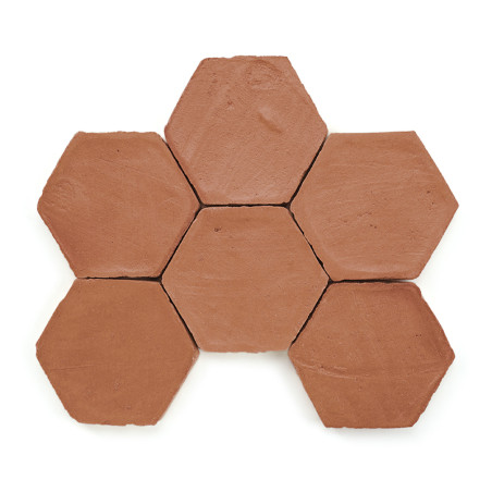 Azulejos hexagonales de terracota dispuestas en forma de panal sobre un fondo blanco, mostrando tonos naturales de color marrón 