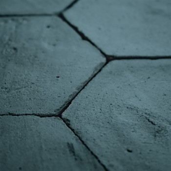 Zeshoekige terracottategels vormen een ruw, verweerd oppervlak en passen strak in elkaar in een close-up architectonische contex