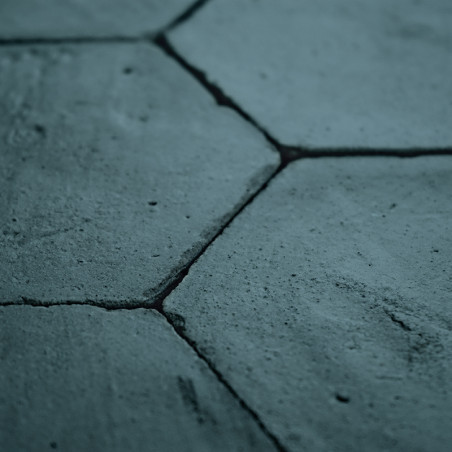 Sechseckige Terrakottafliesen bilden eine raue, verwitterte Oberfläche und fügen sich eng in einen architektonischen Kontext ein