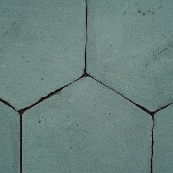 Los azulejos hexagonales de terracota interconectadas, formando un patrón rústico y desgastado, muestran pequeñas grietas y huec