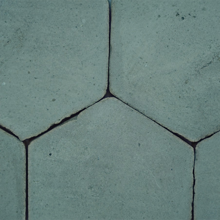 Los azulejos hexagonales de terracota interconectadas, formando un patrón rústico y desgastado, muestran pequeñas grietas y huec
