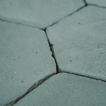 Los azulejos de terracota hexagonales descansan firmemente entre sí, formando una superficie de piso rústica y estampada en tono