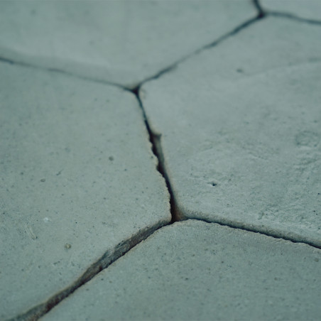 Los azulejos de terracota hexagonales descansan firmemente entre sí, formando una superficie de piso rústica y estampada en tono