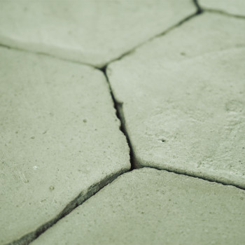 Los azulejos de terracota hexagonales se entrelazan firmemente, formando una superficie plana y sin adornos en un entorno neutro