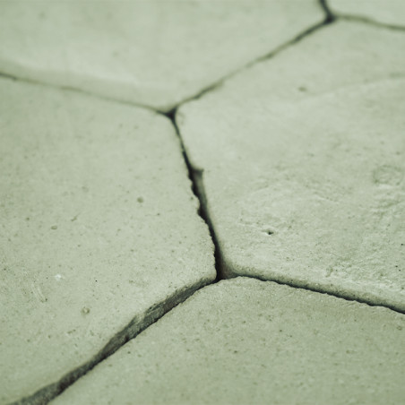 Los azulejos de terracota hexagonales se entrelazan firmemente, formando una superficie plana y sin adornos en un entorno neutro