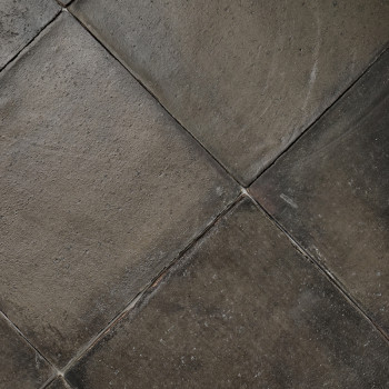 Les carreaux de terre cuite forment un motif terreux et patiné, avec de subtiles variations de texture, s'emboîtent étroitement 