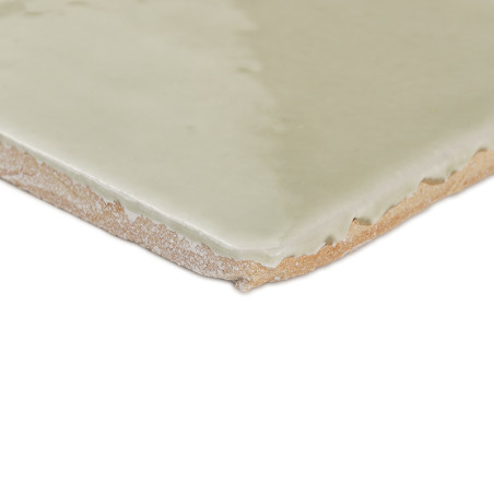 Baldosa de terracota, lisa y esmaltada, se apoya sobre un fondo blanco, resaltando sus bordes texturizados y su superficie brill