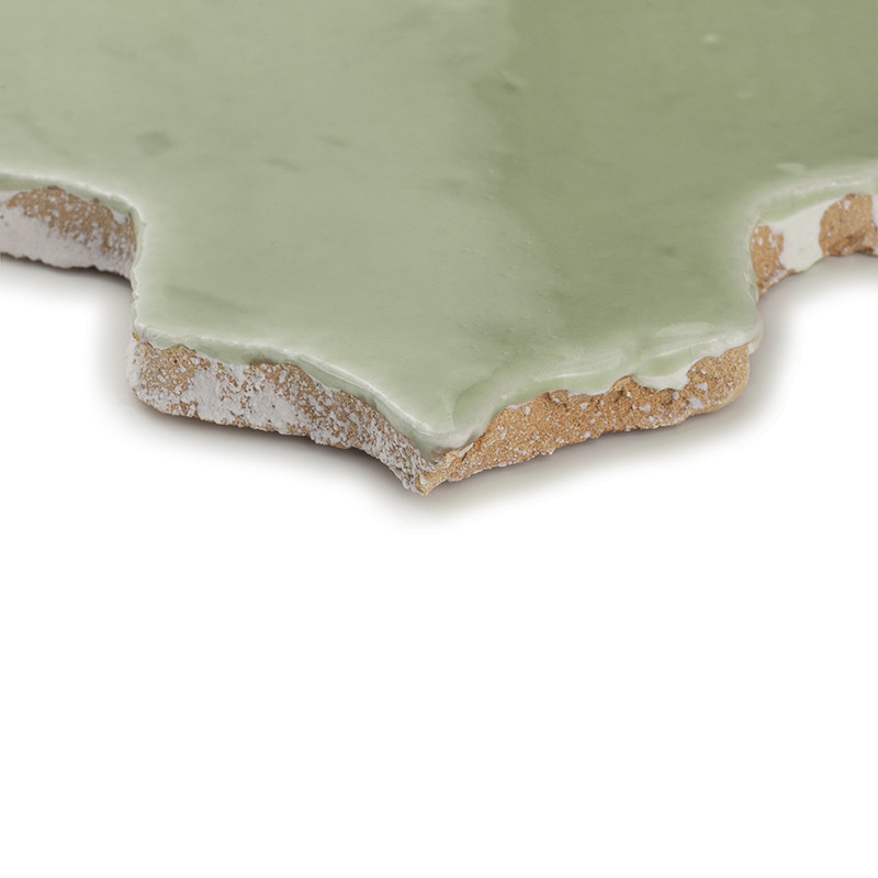 Ladrilhos de terracota verde entrelaçados formam uma superfície padronizada, destacando seu acabamento brilhante e variação suav