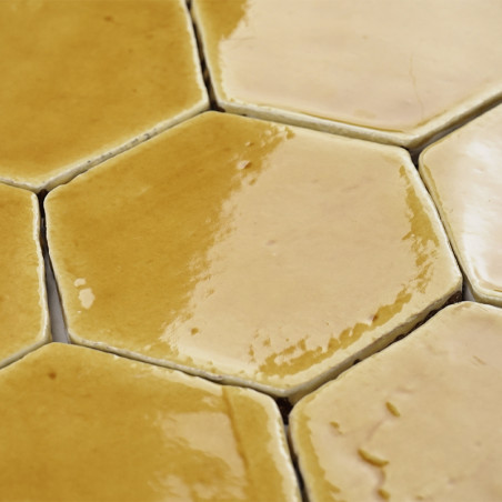 Zeshoekige terracottategels met een glanzende afwerking die in elkaar grijpen, waardoor een warm, aards patroon ontstaat in een 