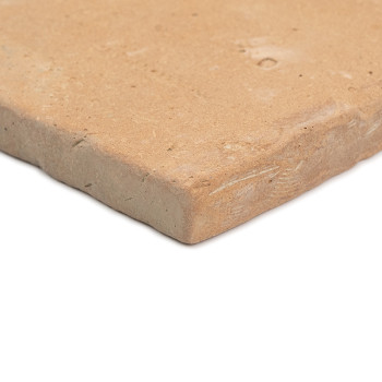 Terracotta tegels liggen op een wit oppervlak, met een ruwe, natuurlijke rand en een matte, aardse textuur.