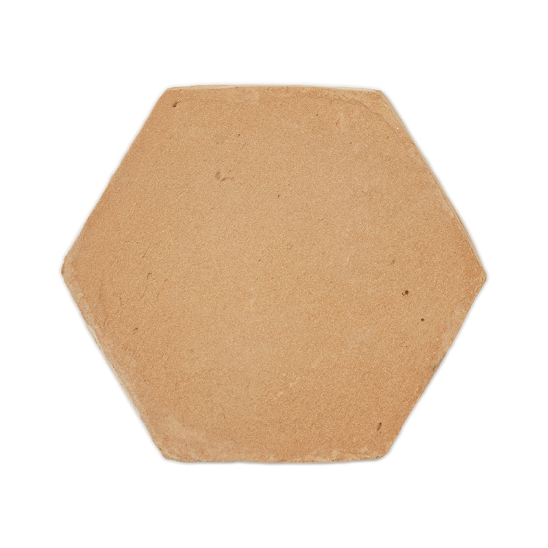 Les carreaux hexagonaux en terre cuite, reposant à plat, présentent une surface d'argile lisse et naturelle avec de subtiles tac