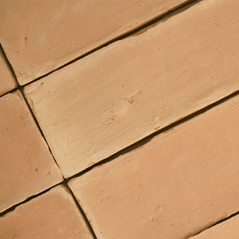 Terracottategels liggen plat en vormen een geometrisch patroon, met een enigszins ruwe textuur en een warme, aardse tint.