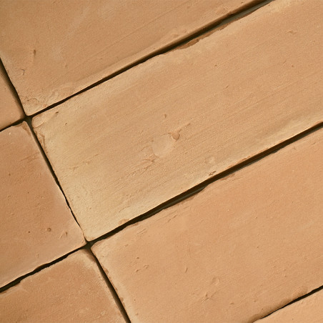 Terracottategels liggen plat en vormen een geometrisch patroon, met een enigszins ruwe textuur en een warme, aardse tint.