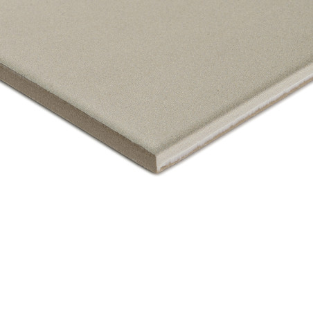 A square, gray ceramic tile with a smooth surface lies on a white background, showing its thickness with a visible edge.