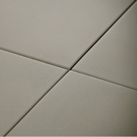 Four smooth, square tiles intersect at a central point. They form a grid pattern in a neutral, beige color.