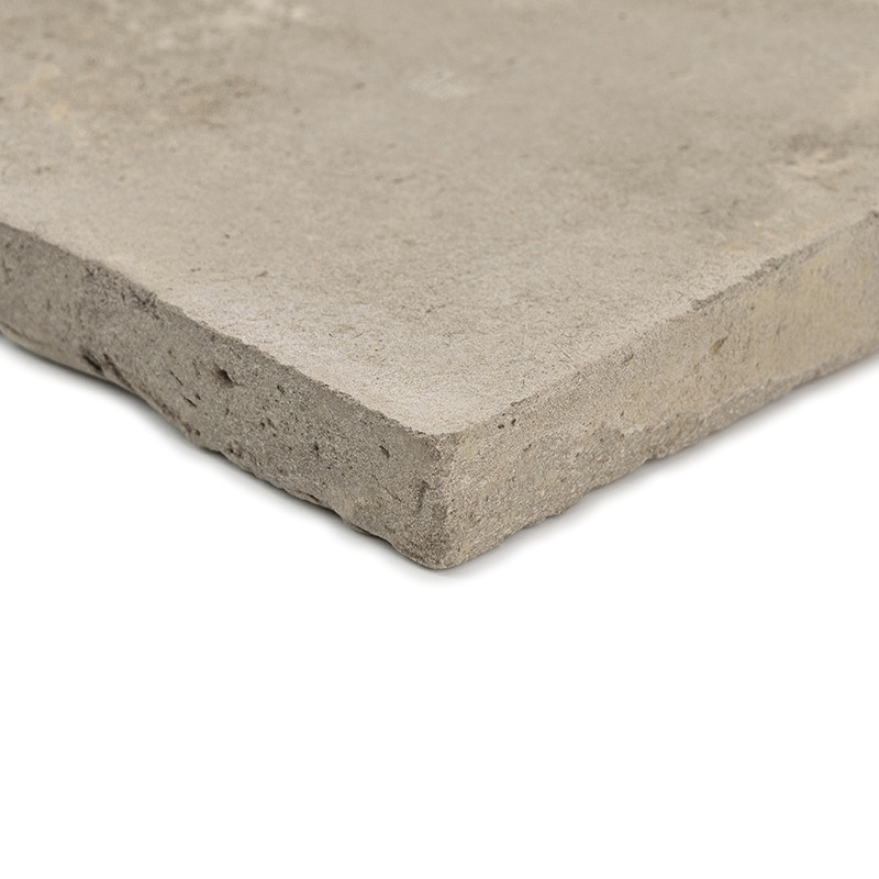 Eine quadratische Terrakottafliese liegt auf einem schlichten, hellen Hintergrund und zeigt eine raue, matte Textur und unbearbe