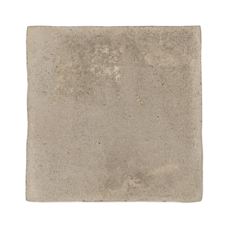 Azulejos cuadradas de terracota con una superficie rugosa y texturizada y un tono beige apagado, aisladas sobre un fondo blanco.