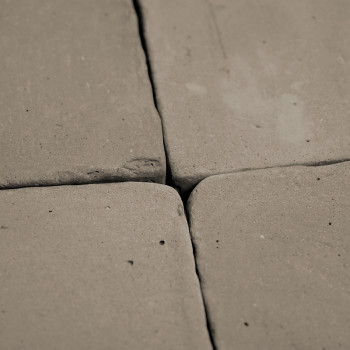 Cuatro Azulejos de terracota, colocadas muy juntas, forman un patrón cuadrado. La superficie muestra una textura rústica e irreg