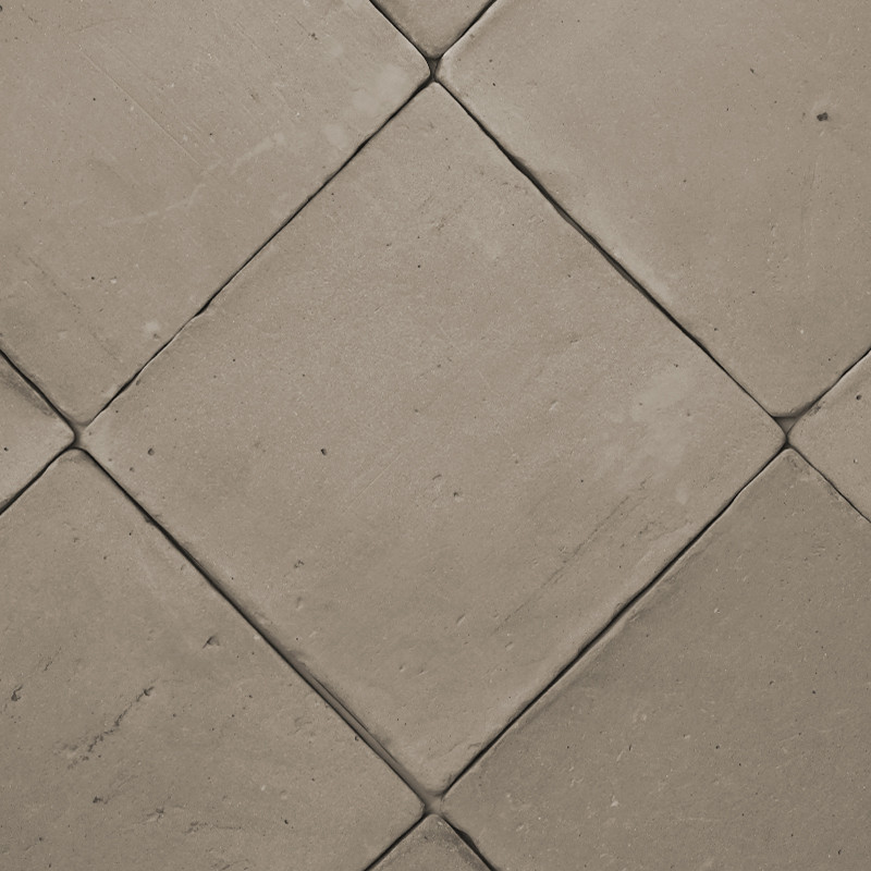 Carreaux de terre cuite disposés en diagonale, créant un motif en losange sur un sol plat de couleur neutre.