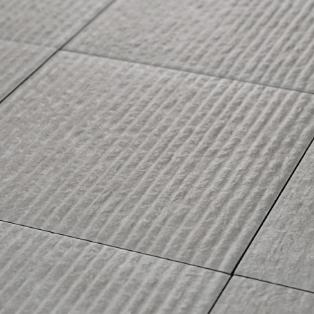 A series of light gray ceramic tiles, textured with evenly spaced horizontal ridges, form a uniformly patterned surface. A series of light gray ceramic tiles, textured with evenly spaced horizontal ridges, form a uniformly patterned surface.