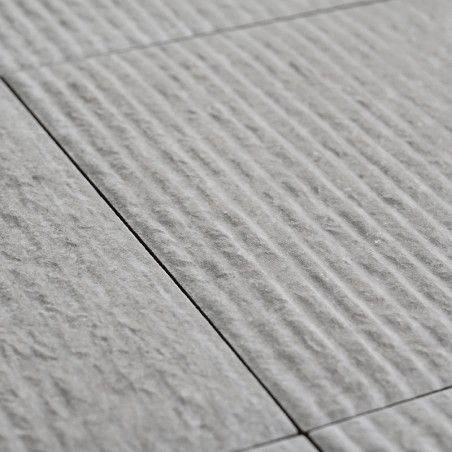 Gray ceramic tiles lie in alignment, featuring a textured surface with linear grooves, creating a subtle pattern across a flat f Gray ceramic tiles lie in alignment, featuring a textured surface with linear grooves, creating a subtle pattern across a flat f