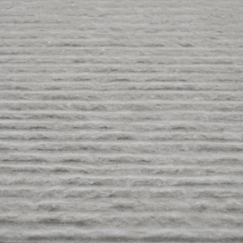 La surface des carreaux gris présente des rainures horizontales uniformes, créant un motif texturé sur toute sa surface, suggéra