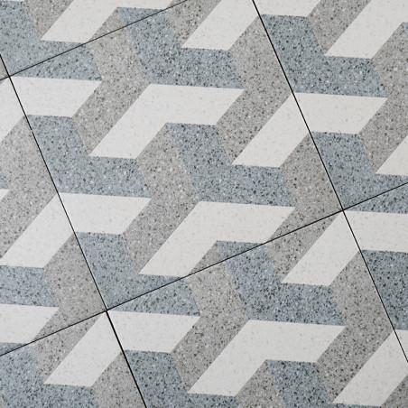 Graue und weiße Fliesen bilden ein geometrisches, ineinandergreifendes Zickzackmuster und sorgen so für einen optisch dynamische