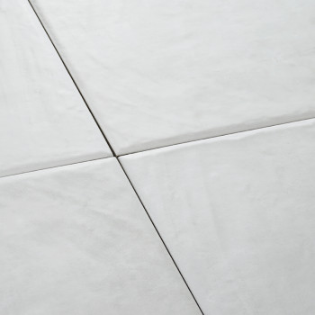 Vier weiße Keramikfliesen bilden ein nahtloses quadratisches Muster und schaffen eine glatte, saubere Oberfläche in einem minima