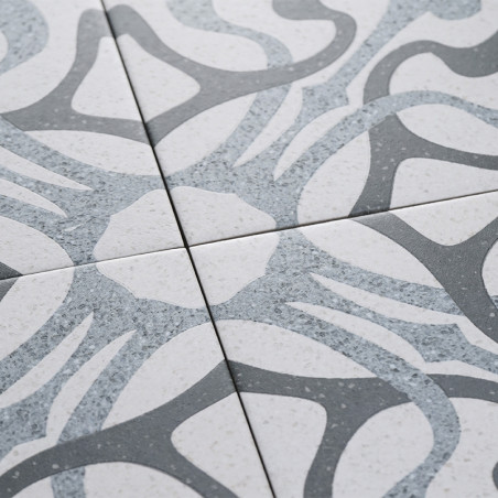 Les carreaux affichent des motifs gris abstraits et courbés sur un fond blanc moucheté, se croisant sur leurs bords pour former 