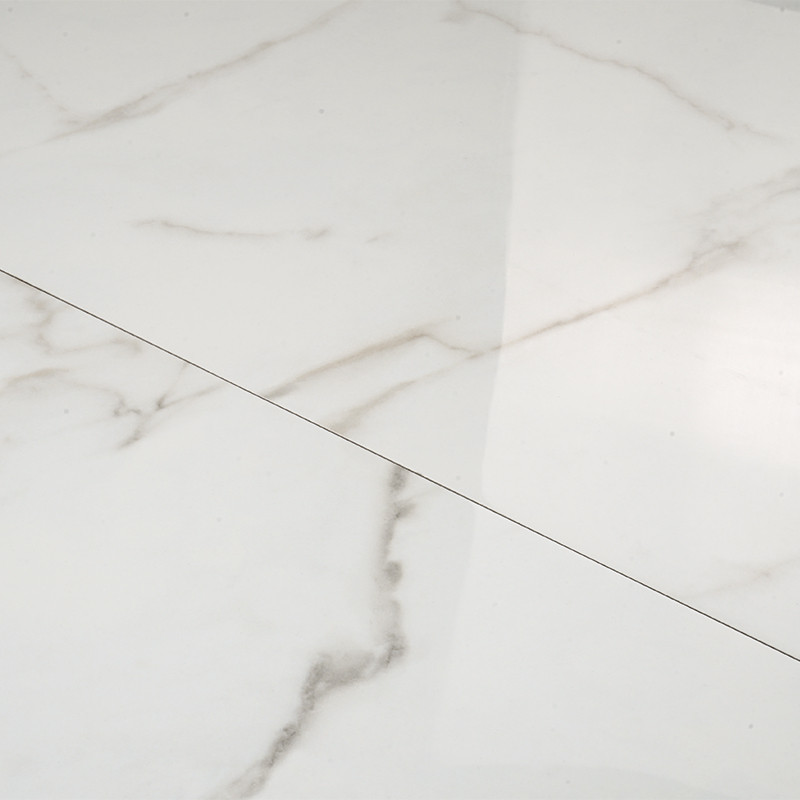Los azulejos de mármol blanco con sutiles vetas grises crean una superficie lisa y pulida que refleja la luz en un ambiente inte