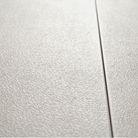 Un carreau beige texturé tient fermement en place, divisé par une ligne de coulis étroite et droite. la surface apparaît granule