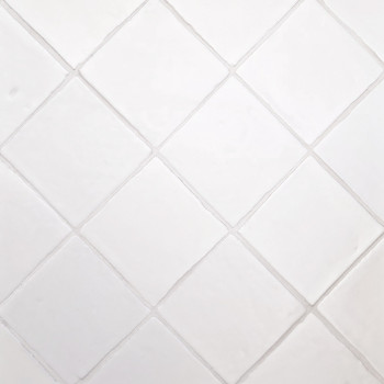 Los azulejos de terracota blanca forman un patrón de cuadrícula diagonal, limpias y espaciadas uniformemente, creando un efecto 